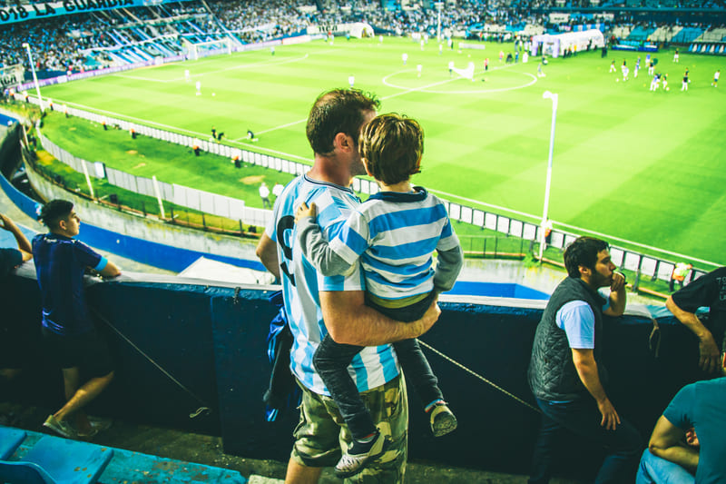 A man with his son watching a futball match in Argentina